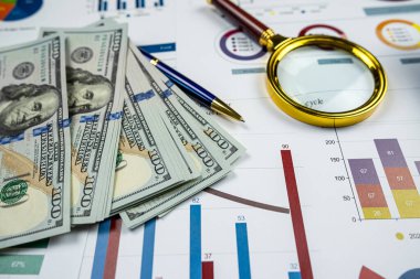 Business graph graphs paper with us dollar bills and magnifying glass. Analytic research data economy