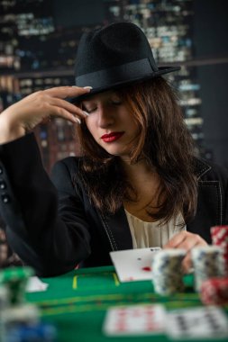 Female poker player beautifully dressed with exquisite perfume with cards in hands at the casino table. Gambling. poker. women in a dangerous game