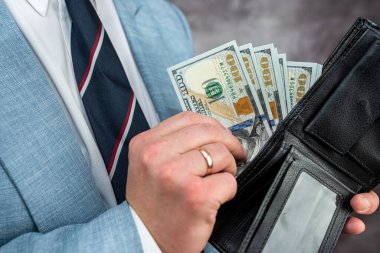 Businessman hands holding black leather wallet with dollar bills. financial concept