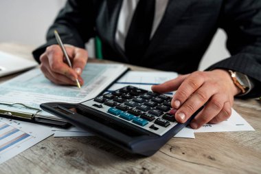 İşadamı vergi formunu ofise dolduruyor, vergilendirme kavramı