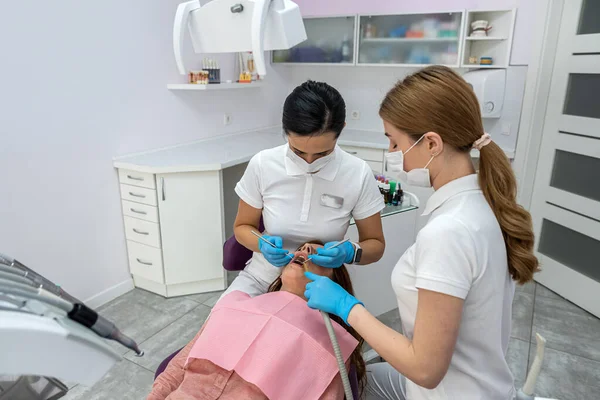 Kadın Asistanı Olan Genç Bir Dişçi Yeni Bir Kızın Dişlerini — Stok fotoğraf