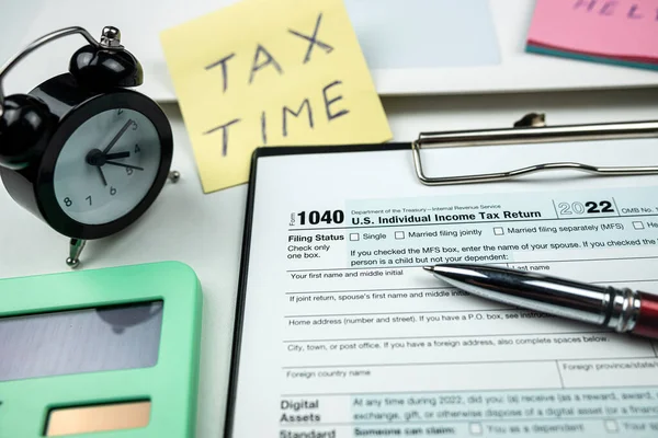 2022年 在我们的1040税单上填入空白处 写字台上有时钟 备忘录 税务时间和笔迹 会计概念 — 图库照片
