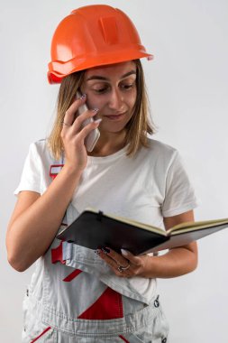 Kadın inşaat işçisi elinde dosyayla arka planda izole edilmiş belgeler tutuyor. Bir kadın portresi. onarım