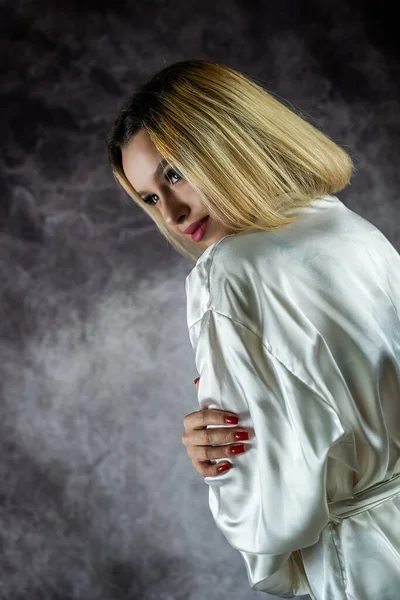 一个穿着浅色丝绸长袍 背景朴素的性感年轻女人 一个女人的孤立画像 — 图库照片