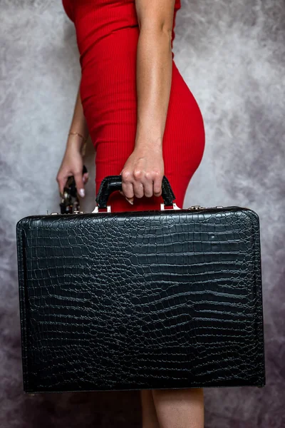 stock image woman in red dress with gun and black suitcase isolated, crime concept
