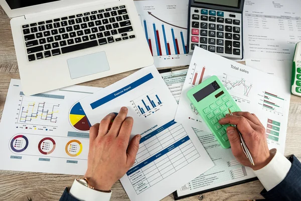 closeup of accountant hand work with accountancy document chart and diagram with pen and calculator  