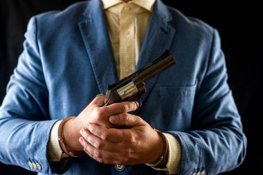 Smokinli, elinde tabancayla siyah arka planda izole edilmiş vahşi bir caninin kesilmiş fotoğrafı. Yaşam tarzı. Gangster iş başında. Katil silahı doğrulttu. Ateşli silah kullanıyor..