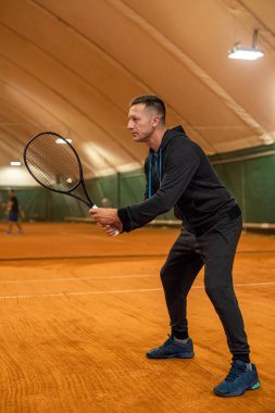 Kapalı alanda tenis oynayan çevik erkek sporcunun tam boy portresi. kopyalama alanı. Spor oyunu Atletizm. Tenis. saray