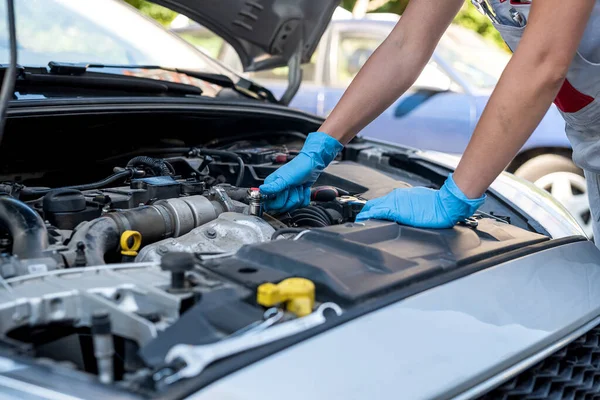 女性の自動車サービス技術者が車サービスセンターで顧客の車を検査して修理します 車体とサスペンションシステムの下で車をチェックします 車両修理工場 — ストック写真