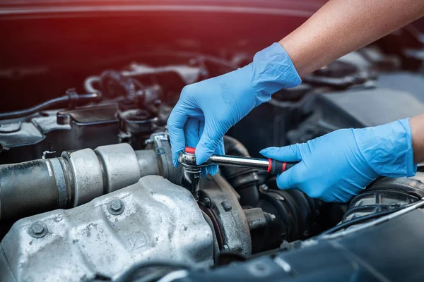 車の整備士の女性は壊れた車とガレージで働く 修理サービス 車を修理する女性の手のクローズアップ — ストック写真
