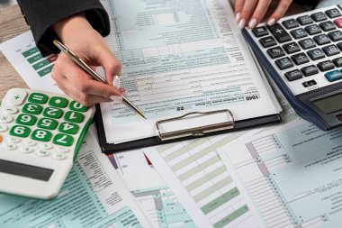 Ofiste 1040 vergi formunu dolduran yakın plan kadın. Bitiş tarihi muhasebe kavramı