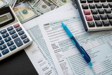 2022 Blank vergi formu 1040 nakit hesap makinesi ve kalemle birlikte. Muhasebe yıllık raporu