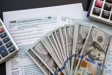 boş 1040 vergi formunun üzerinde dolar nakit kalem ve hesap makinesi. Yıllık rapor, evrak işleri