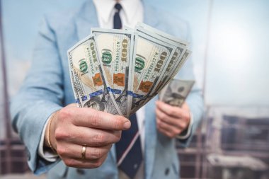 Erkek eli yakın çekim dolar sayar. Yatırım nakit ve maaş kavramı