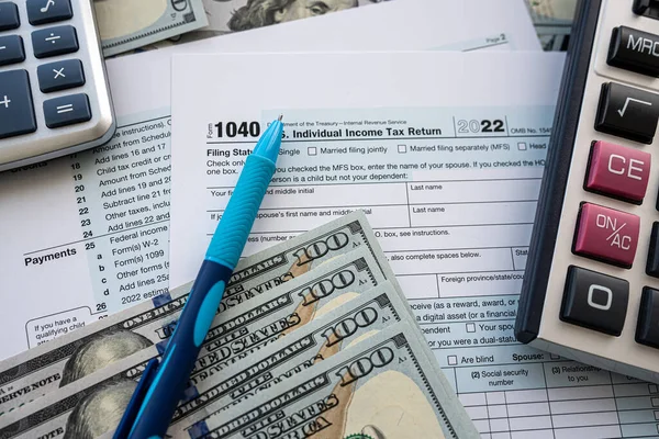 在空白的1040税单上填写美元现金笔及计算器 年度报告 — 图库照片
