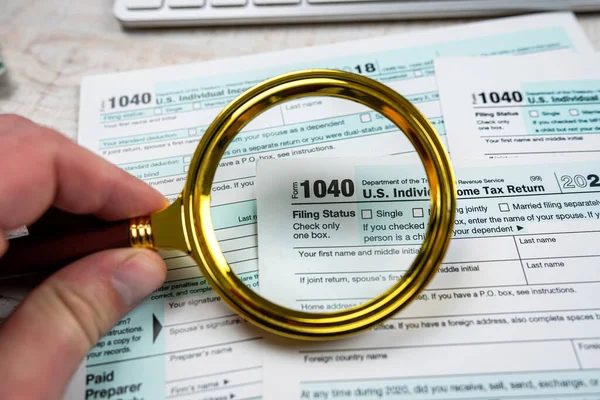 blank of individual tax form with magnifying glasses, tax and income concept