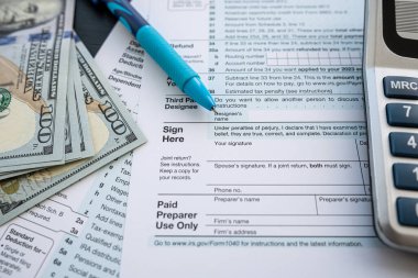 2022 Blank vergi formu 1040 nakit hesap makinesi ve kalemle birlikte. Muhasebe yıllık raporu