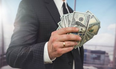 Erkek eli yakın çekim dolar sayar. Yatırım nakit ve maaş kavramı