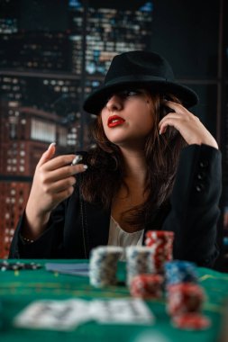 image of a young sexy woman playing poker with a cigarette and smoke coming out of it. poker in the casino. woman with cards