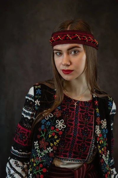 伝統的なウクライナの服の赤い刺繍のドレススタジオで美しい白人女性は暗い背景を撮影します ファッションコンセプト — ストック写真