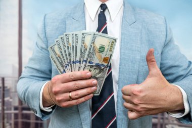 Yakından 100 Amerikan doları banknotlar erkeklerin elinde. Başarılı işadamının elinde para var.