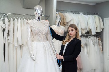 young woman seamstress seller posing in wedding salon. wedding day