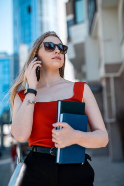 Beautiful woman with glasses and walking and talking on mobile phone. Wireless communication. Business technologies. Businesswoman portrait.