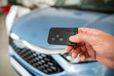 Showroom 'da yeni modern arabaya karşı erkek eliyle anahtar, başarı satışı veya kira anlaşması, ulaşım konsepti