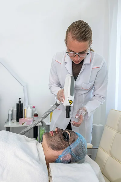 Imagem Esteticista Aplicando Uma Máscara Barro Com Uma Escova Rosto — Fotografia de Stock