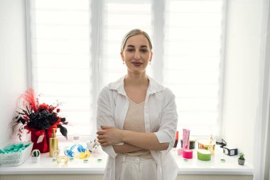 Masör masaj aletlerini tutar ve müşteriyi beklerken kameraya poz verir.