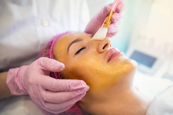 Estetista Applica Una Maschera Dorata Viso Una Donna Cosmetologia Cura — Foto Stock