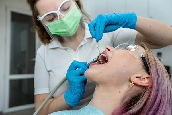 Europejska Młoda Kobieta Siedzi Krześle Medycznym Podczas Gdy Dentystka Naprawia — Zdjęcie stockowe