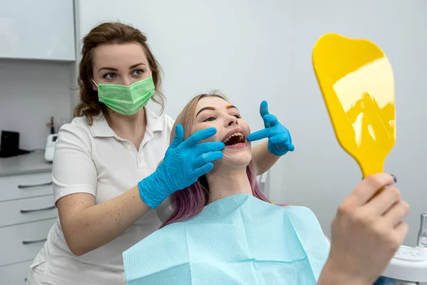 専門医が歯を検査する間 医療センターの歯科椅子に座っている満足した若い女性のイメージ 健康な口腔です 美しい笑顔の歯科医 — ストック写真