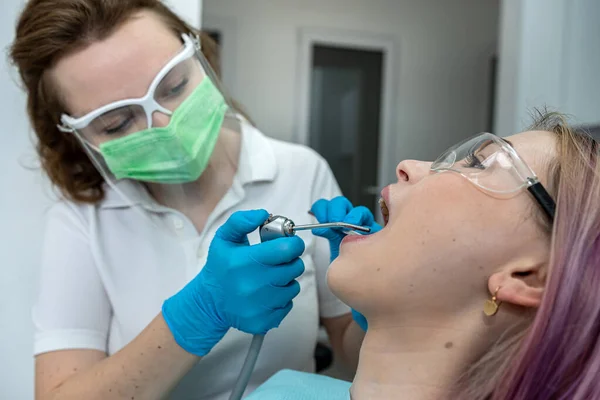 Europejska Młoda Kobieta Siedzi Krześle Medycznym Podczas Gdy Dentysta Naprawia — Zdjęcie stockowe