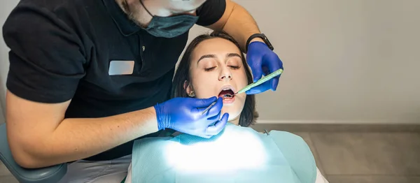 Exame Dentista Que Trata Paciente Consultório Dentário Uma Mulher Tem — Fotografia de Stock