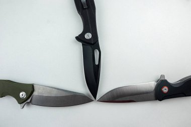 Beyaza saplanmış üç siyah taktik savaş bıçağı. silah