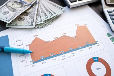 Kalem, hesap makinesi ve dolarla yıllık mali raporlar. Finans yatırım kavramı