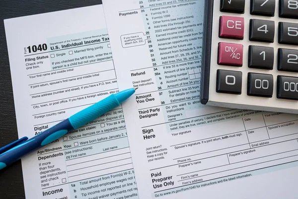 事務机の上にペンと電卓付き1040税フォーム 年次報告書 税の時期 — ストック写真