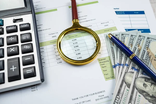 business graphs paper with dollar bills magnifying glass calculator and pen on office desk. Growth charts, Stock exchange trading