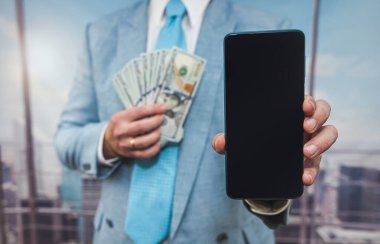 businessman in suit hold dollar and tablet at office, online purchase concept