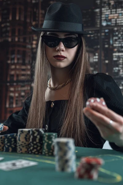 Poker oynayan, fiş tutan, bahis oynayan, yükselen güzel bir genç kadın. Kadın kazanıyor.