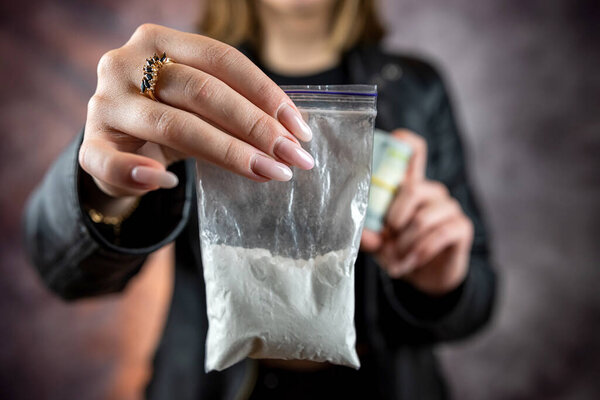 Packet with cocaine narcotic powder in female dealer, crime concept. Danger addiction overdose concept.
