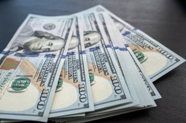 Siyah arka planda 100 yeni Amerikan doları. Gelir geliri. Kaydetme kavramı