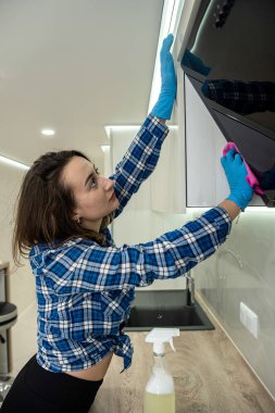 young energetic woman cleans a modern kitchen with modern means of cleaning dirt in inaccessible places. clean kitchen the woman cleans. purity