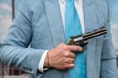 closeup agent in blue suit holding semi-automatic pistol gun. ganster or killer