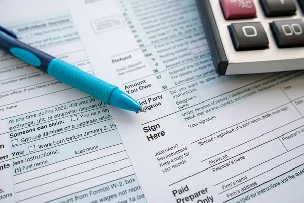 事務机の上にペンと電卓付き1040税フォーム 年次報告書 税の時期 — ストック写真