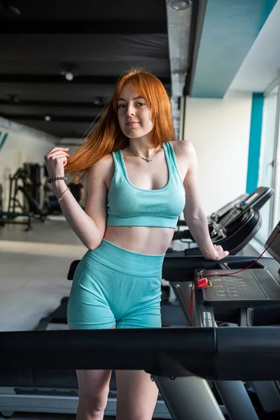 Mladá Rusovlasá Žena Sportovní Odpočinek Blízkosti Běžeckého Pásu Cvičení Tělocvičně — Stock fotografie