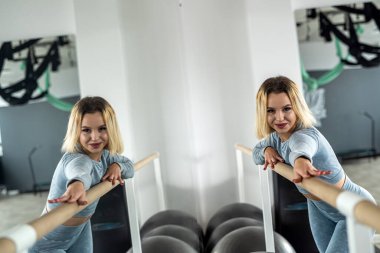 Beautiful girl poses with a smile in front of the mirror in the gym before training. sport. fitness fitness woman in front of the mirror