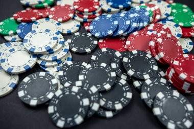 Siyah bir masaya saçılmış renkli kumarhane poker fişleri. yalnız poker. Kumarhane Kumar ya da para için oyun