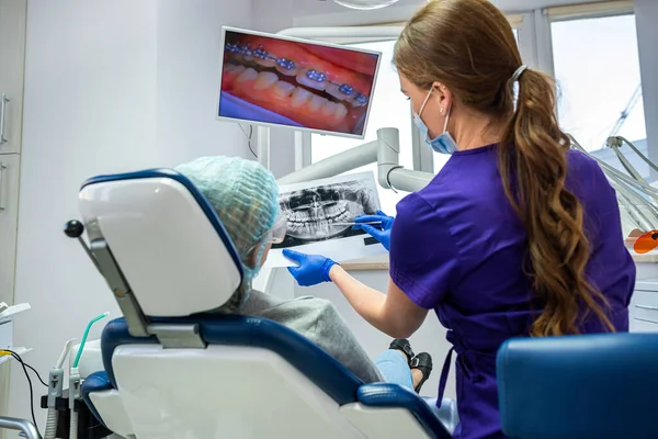 in professional dentistry, a dentist who knows his business takes pictures for a patient with diseased teeth. The concept of pictures of teeth in patients
